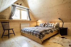 a bedroom with a bed in a wooden cabin at TatryTOP Chatka Kratka in Zakopane