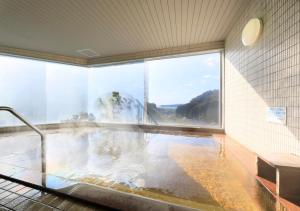 Habitación con piscina de agua y ventana en Katsuura Hilltop Hotel & Residence, en Katsuura