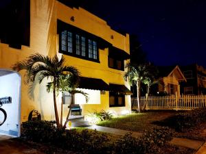 a yellow building with palm trees in front of it at TWO BEDROOM HOME IN BEAUTIFUL DOWNTOWN LAKELAND in Lakeland