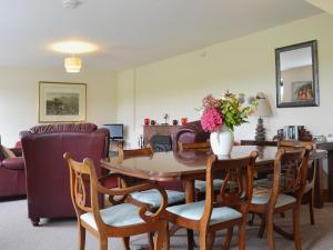 een woonkamer met een tafel en stoelen bij Rose Cottage - Beaufort Estate in Belladrum