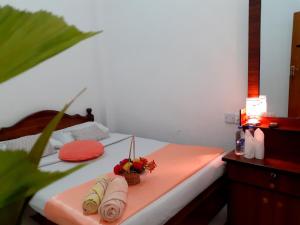 a bedroom with a bed with towels and a table at Subash Hotel in Nallathanniya