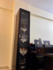 a tall black cabinet with glasses in a room at سيرينا العلمين عائلات ممنوع الجروبات والميكسات in Abū Shunaynah