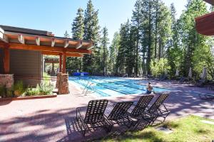 a pool with chairs and a person sitting in front of it at 3174 Aspen Grove in Truckee