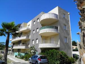 a building with a car parked in front of it at Appartement 2 pièces avec climatisation, parking, proche plage, commerces et activités - Classé 3 étoiles - FR-1-338-426 in Sète