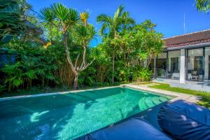 a swimming pool in a backyard with a house at Villa Brezze - Nusa Dua in Nusa Dua