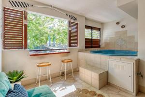 道格拉斯港The lookout Lux Spa, Heart of Port Douglas MK的一间带浴缸和两个凳子的浴室