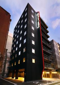 Ein schwarzes Gebäude mit einem Schild an der Seite. in der Unterkunft FL Hotel Dotonbori in Osaka