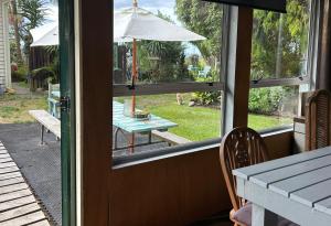 an open door of a patio with a table and an umbrella at Morepork Rural Oasis in Aongatete