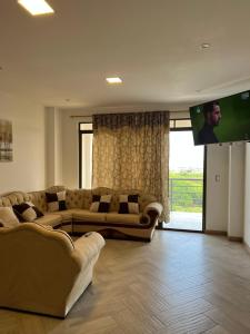 een woonkamer met 2 banken en een flatscreen-tv bij Apartamento Violeta con Impresionante Vista al Mar in Playas