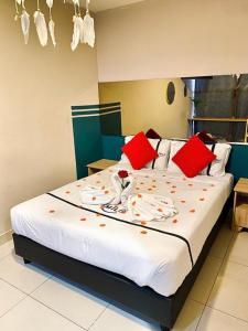 una camera da letto con un grande letto con cuscini rossi di Seeds Hotel PV128 Setapak a Kuala Lumpur