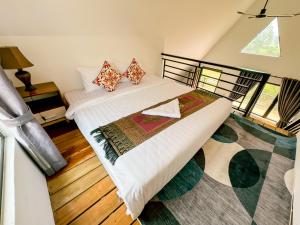 two beds in a room with wooden floors at HaiVen Farm Homestay in Phumĭ Khŭn Réam