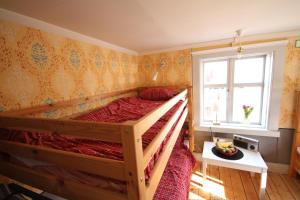 a bedroom with a wooden bed and a window at Mallboden Café & Vandrarhem in Motala +10 photos