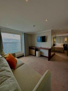 Sala de estar con sofá, cama y TV en Costa do Sal Hotel Boat Lounge, en Aveiro