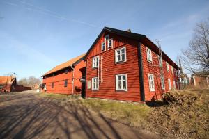 a large red barn with white windows next to a road at Mallboden Café & Vandrarhem in Motala
