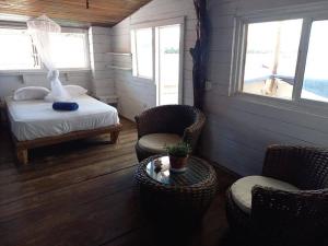 a bedroom with a bed and two chairs and a table at Elba House in Bocas del Toro