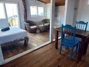 um quarto com uma mesa e cadeiras azuis e uma mesa e uma mesa e cadeiras em Elba House em Bocas del Toro