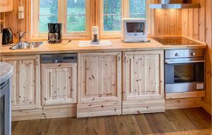 a kitchen with wooden cabinets and a counter with a microwave at Beautiful Home In Sjusjoen in Sjusjøen
