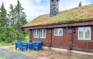 a house with a grass roof with a table and chairs at Beautiful Home In Sjusjoen in Sjusjøen