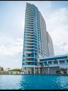 wysoki budynek z basenem przed nim w obiekcie Apto de Playa con una Hermosa vista frente al mar w mieście Nueva Gorgona
