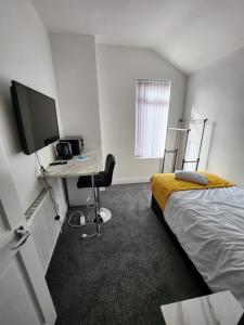 a room with a bed and a desk with a computer at Bamville Shared House in Birmingham