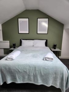 a bedroom with a large bed with two pictures on the wall at Bamville Shared House in Birmingham