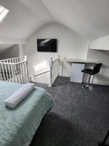 a bedroom with a bed and a desk and a television at Bamville Shared House in Birmingham