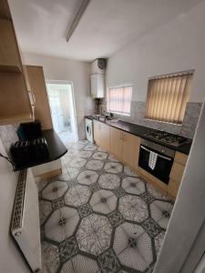 een keuken met een vloer met een patroon erop bij Bamville Shared House in Birmingham