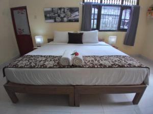 een slaapkamer met een groot bed en 2 handdoeken bij Rindu Homestay in Undisan