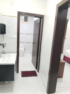 uma casa de banho com um WC, um lavatório e um espelho. em هوتيل نجران للشقق الفندقية em Najran