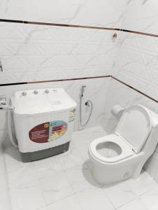 - une salle de bains blanche pourvue de toilettes et d'un réservoir d'eau dans l'établissement هوتيل نجران للشقق الفندقية, à Najran