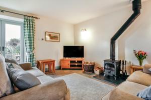 a living room with a couch and a stove at No 2 The Stables in Llangefni