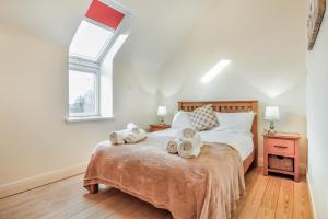 a bedroom with a bed with towels on it at No 2 The Stables in Llangefni