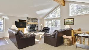 a living room with leather chairs and a fireplace at Wallowa 10 in Sunriver