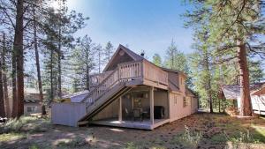 une grande maison avec une terrasse dans les bois dans l'établissement Deer - 19, à Sunriver