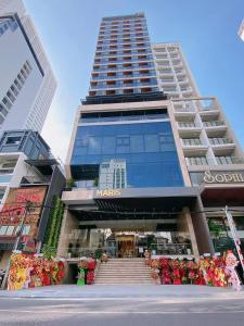 a large building with stairs and flowers in front of it at Maris Hotel Nha Trang in Nha Trang