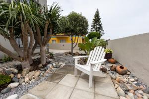 a white chair sitting in the middle of a garden at Guesthouse Fischreiher B&B in Swakopmund
