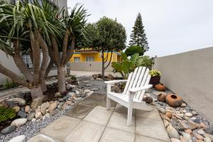 una silla blanca sentada en medio de un jardín en Guesthouse Fischreiher B&B en Swakopmund