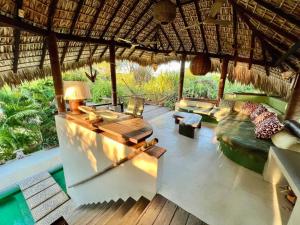 a living room with a couch and a table at Casa KUUL, elegant fusion of house and garden. in Puerto Escondido +6 photos