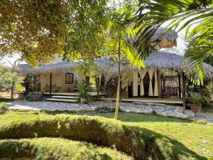 a house with a grass roof and a yard at Casa KUUL, elegant fusion of house and garden. in Puerto Escondido