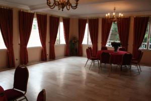 - une salle à manger avec une table, des chaises et des fenêtres dans l'établissement Hôtel Saint Alban, à Saint-Maur-des-Fossés
