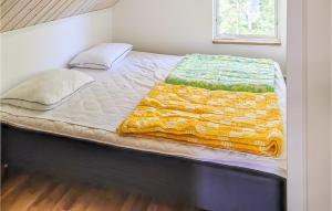 a large bed with a yellow and green blanket on it at Beautiful Apartment In Gotlands Tofta in Gnisvärd +6 photos
