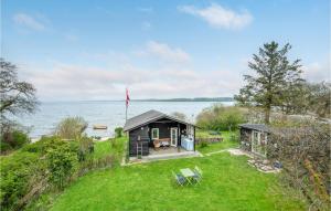 a small house on the shore of a body of water at Cozy Home In Skanderborg With Kitchen in Skanderborg