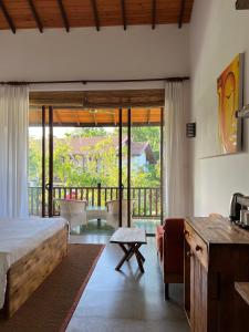 1 dormitorio con cama y vistas a un balcón en Palm Garden Ayurveda Resort, en Ahangama