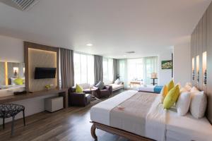 a bedroom with a large bed and a living room at Aochalong Villa Resort & Spa - SHA Plus in Chalong 