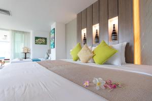 a bedroom with a large bed with green and white pillows at Aochalong Villa Resort & Spa - SHA Plus in Chalong 