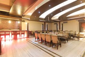 ein Restaurant mit Tischen und Stühlen und eine Bar in der Unterkunft Hotel Mohan in Lucknow