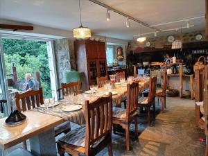 a man sitting at a long table in a restaurant at La myrtilleraie in Péreyres