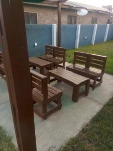 three wooden benches sitting on a sidewalk in a yard at Danson Lodge Guest House in Pokuase