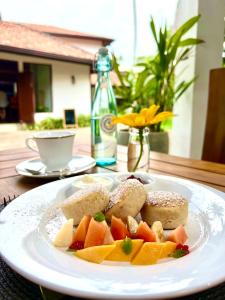 un plato de comida con fruta en una mesa en Palm Garden Ayurveda Resort, en Ahangama