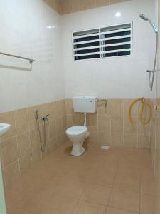 y baño con aseo y ducha. en Happy homestay sitiawan en Sitiawan